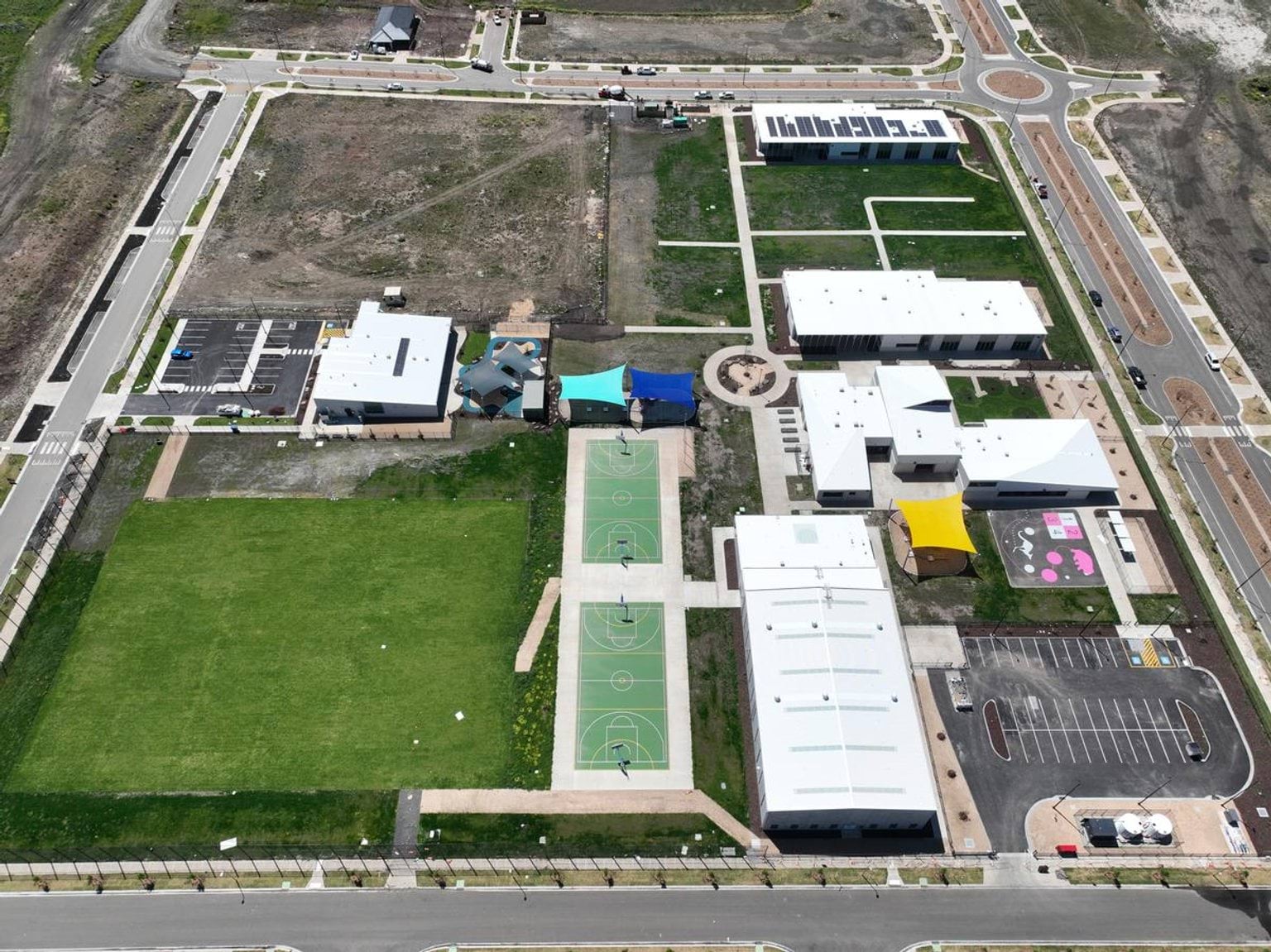 An aerial photo of the progress at Muyan Primary School. Many buildings look finished, and there is grass growing in.