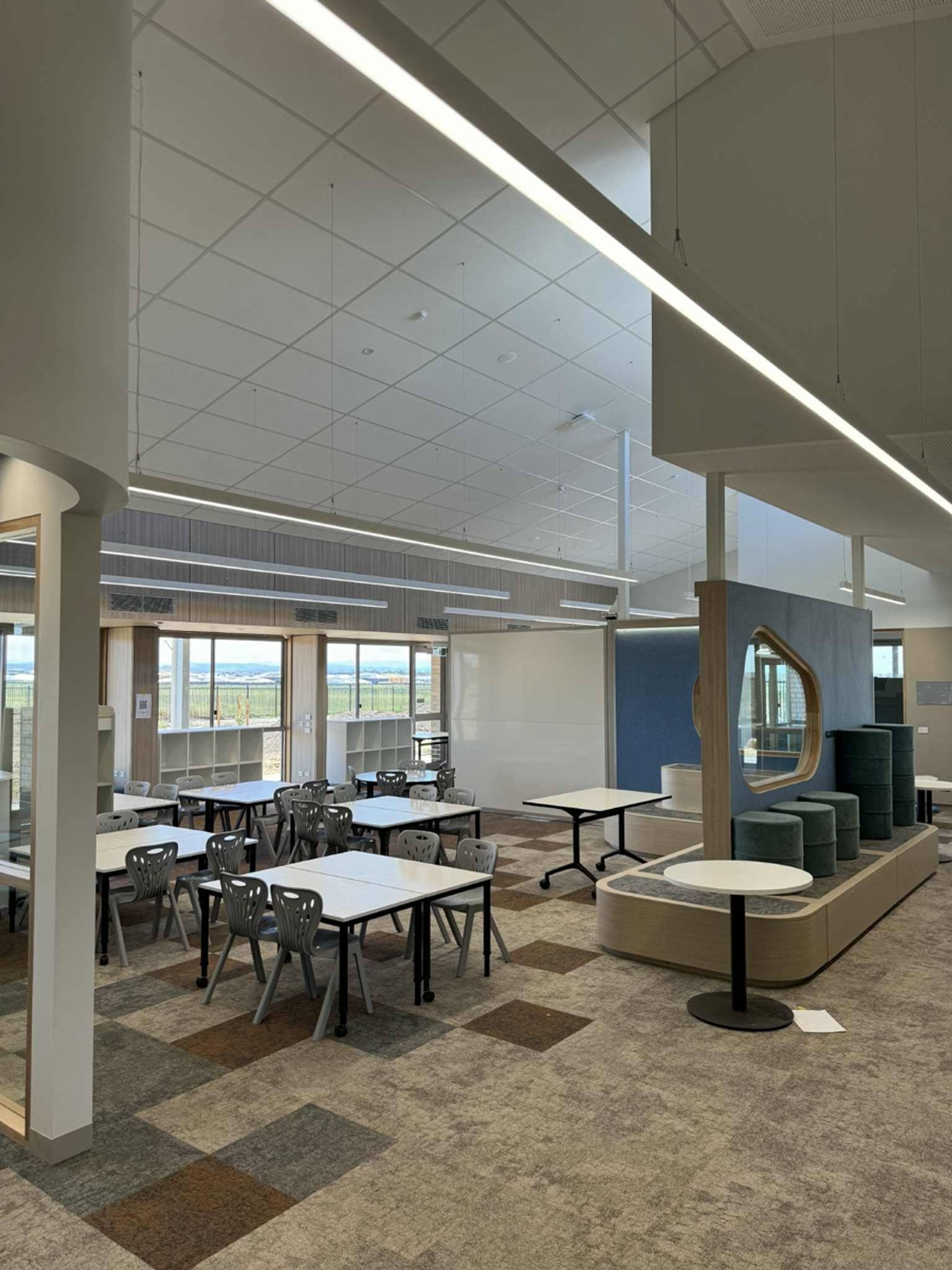 Inside a classroom of Balambalam Primary School. There are big tables with lots of chairs.