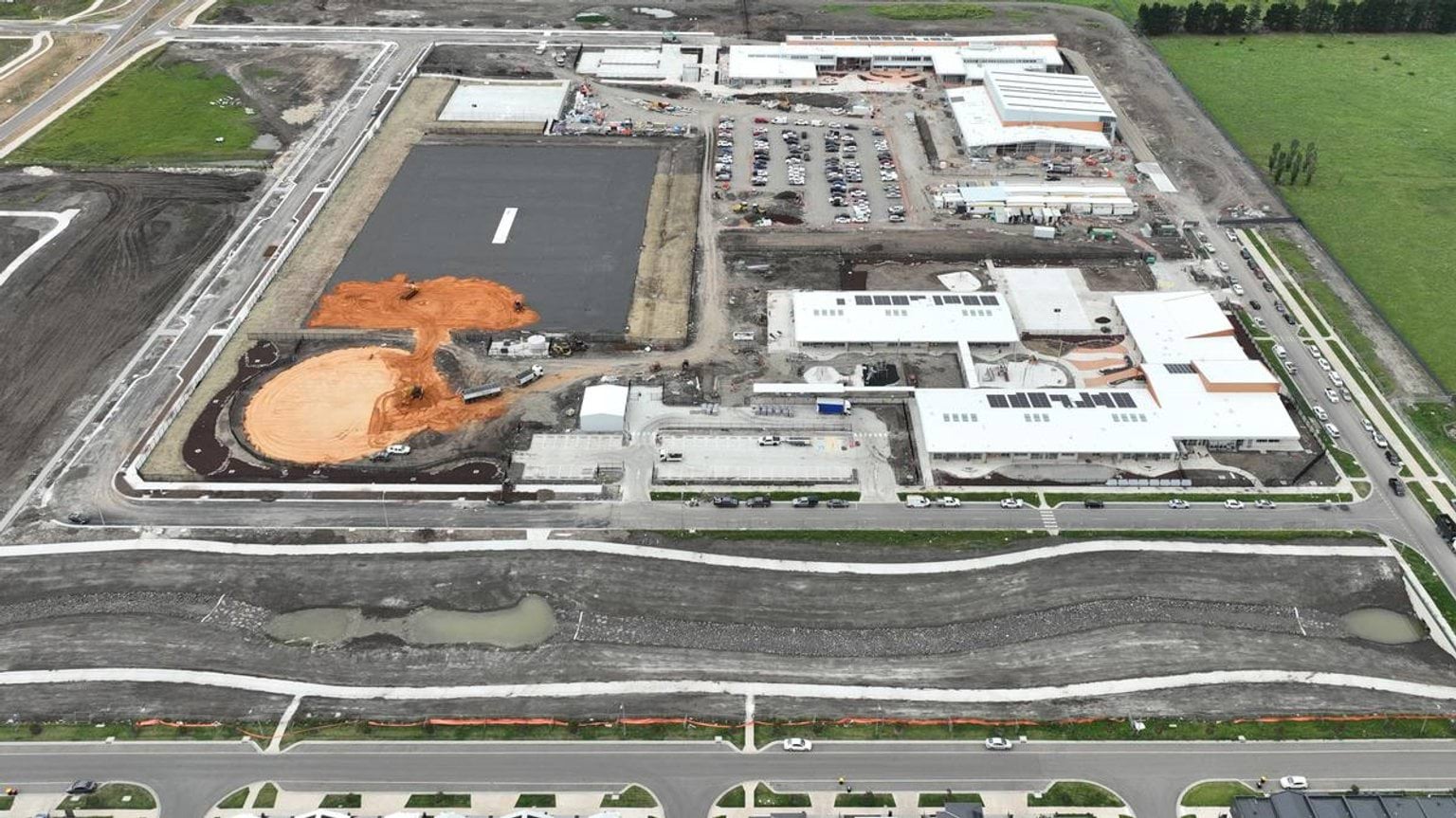 Aerial photo of construction site. There are school buildings in various stages of construction.
